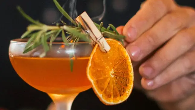 Cocktail pyntet med appelsin og rosmarin